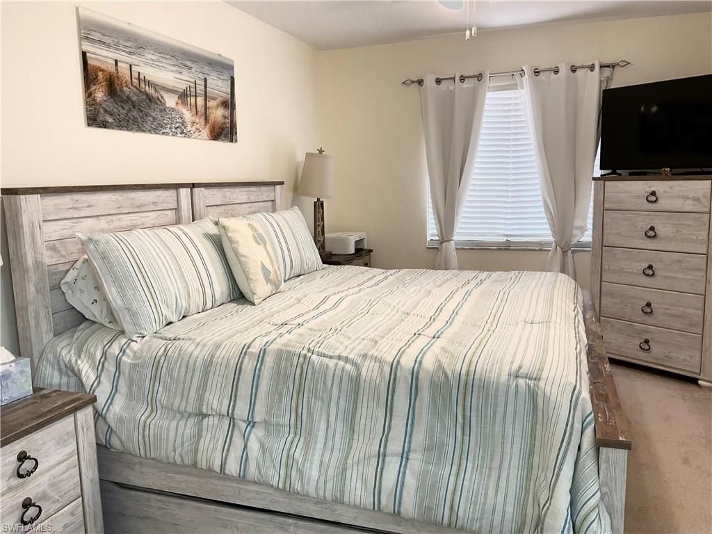 7380 St Ives Way, Unit 1204 Naples, FL 34104 - Photo 17 of 33 a bedroom with a bed and a flat screen tv