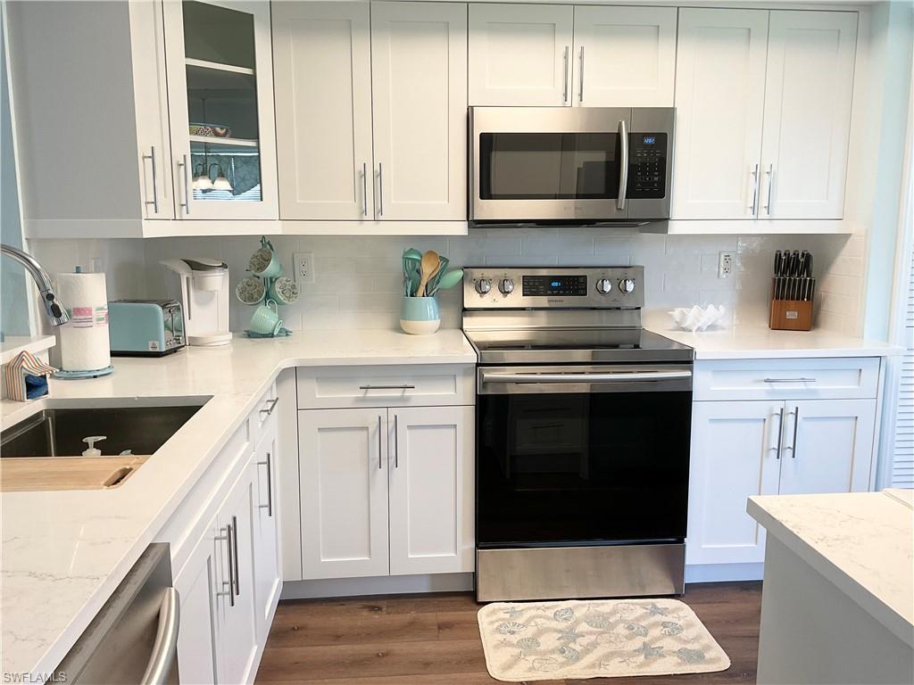 7380 St Ives Way, Unit 1204 Naples, FL 34104 - Photo 8 of 33 a kitchen with stainless steel appliances granite countertop a stove microwave and sink