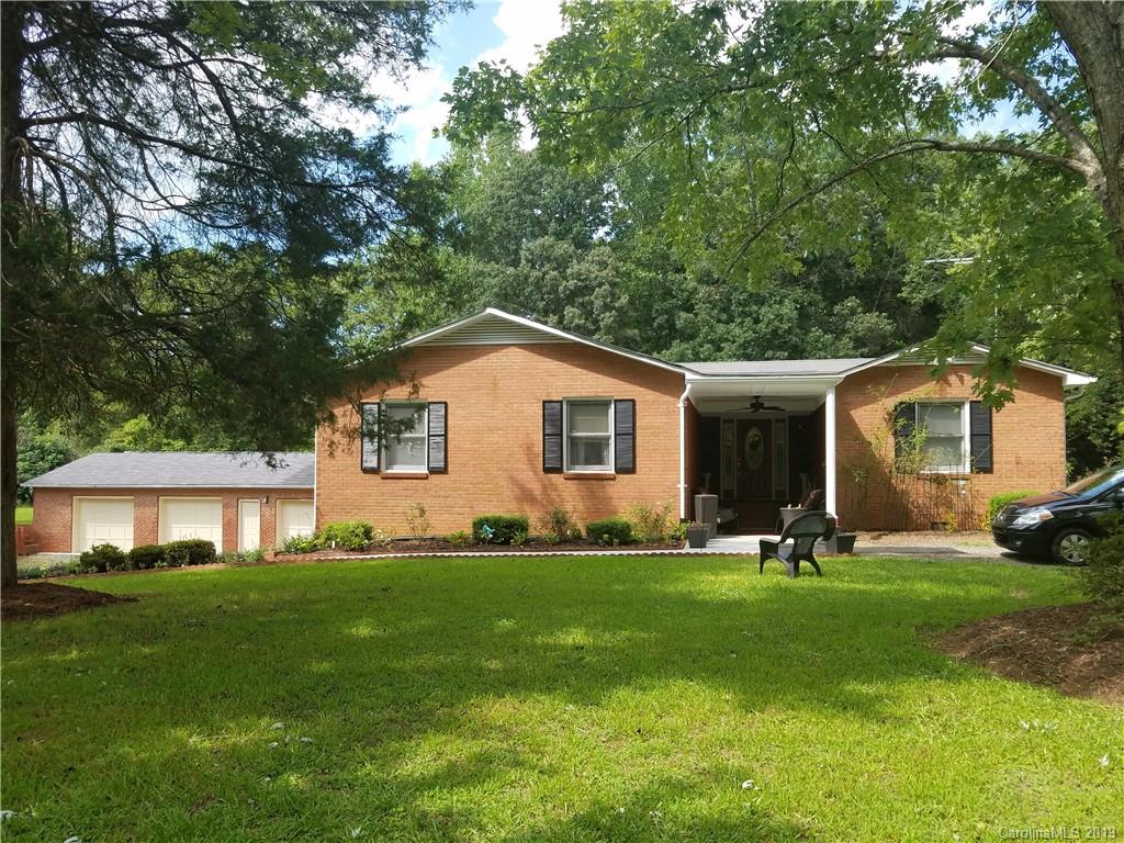 a front view of a house with a yard and trees