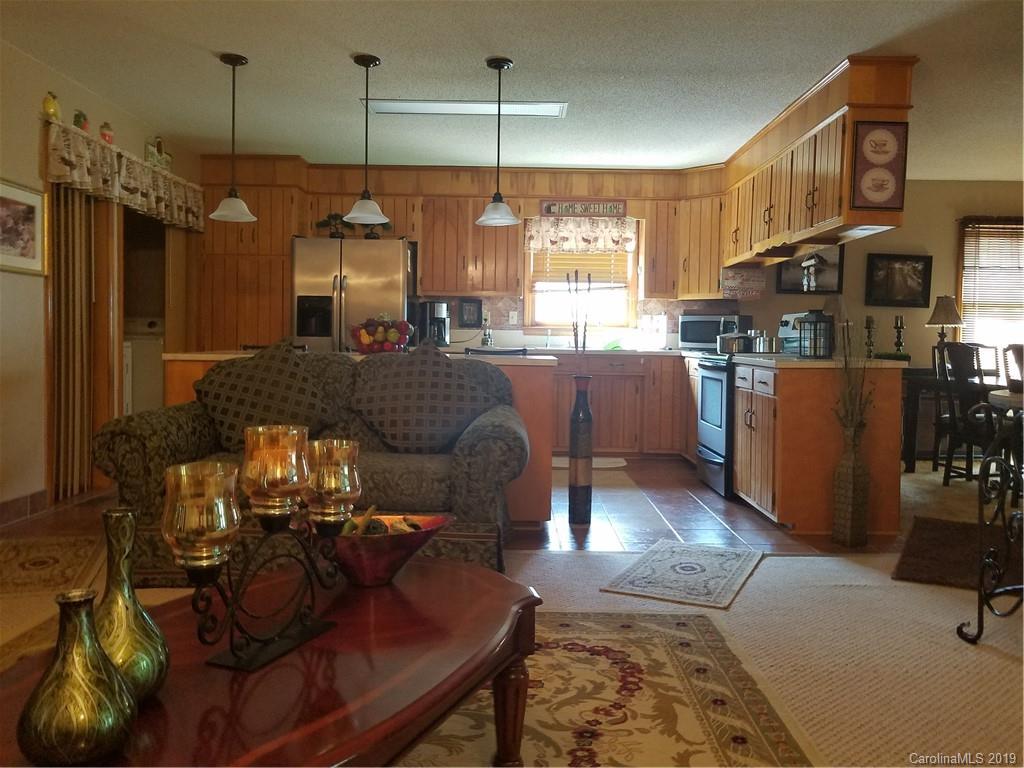 1313 Blacksnake Road Stanley, NC 28164 - Photo 6 of 17 a living room with furniture a dining table and a chandelier