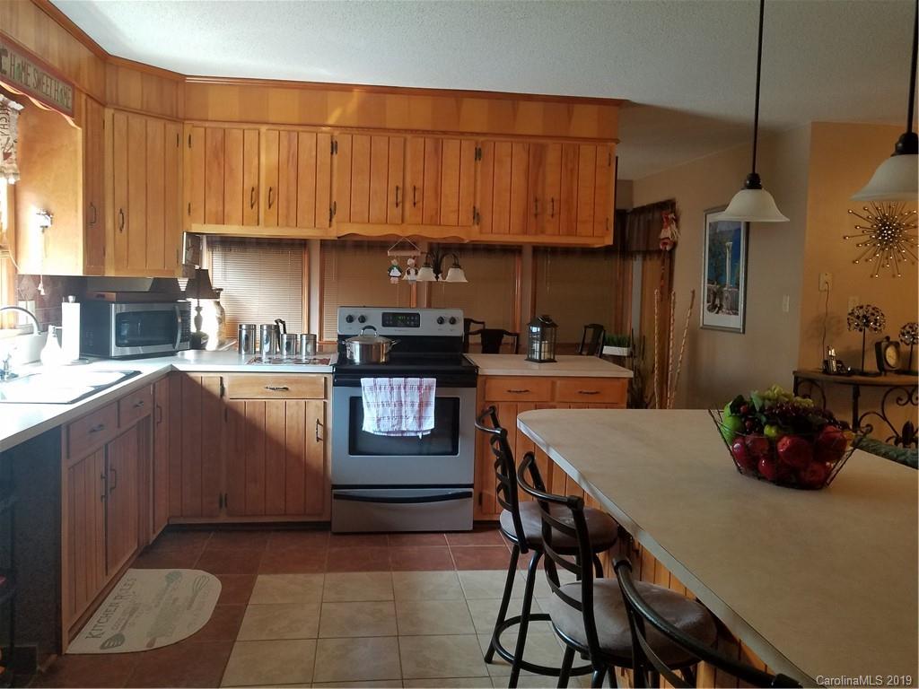 1313 Blacksnake Road Stanley, NC 28164 - Photo 7 of 17 a kitchen with a sink a stove and chairs