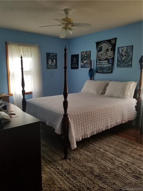 1313 Blacksnake Road Stanley, NC 28164 - Photo 10 of 17 a bedroom with a large bed a chandelier and a window