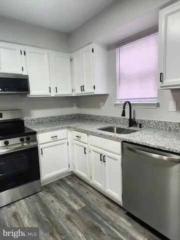 a kitchen with granite countertop cabinets stainless steel appliances and a sink