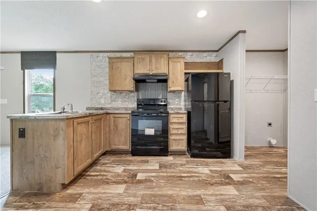 a kitchen with granite countertop a refrigerator and a stove top oven