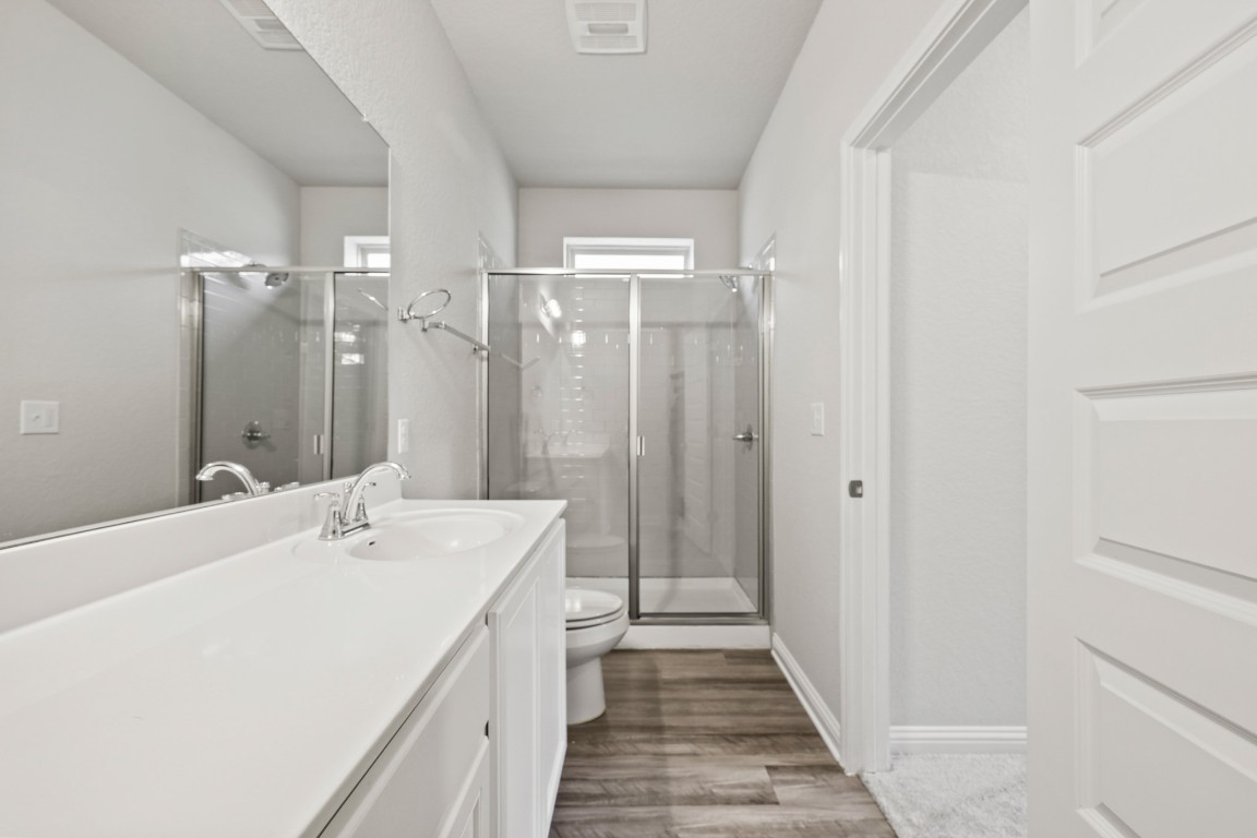 8105 Frida Bend Austin, TX 78744 - Photo 11 of 24 a spacious bathroom with a double vanity sink and a mirror