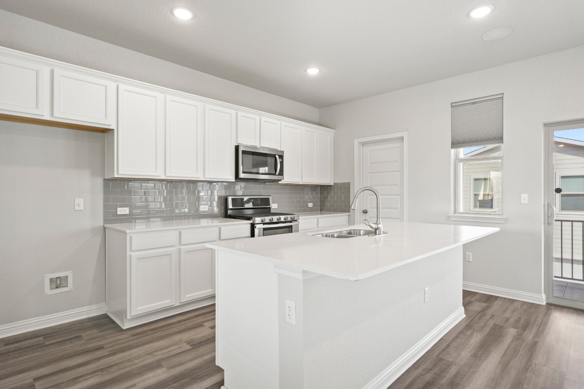 8105 Frida Bend Austin, TX 78744 - Photo 5 of 24 a kitchen with sink a microwave and cabinets