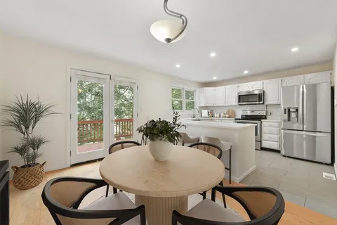 a kitchen with sink refrigerator dining table and chairs