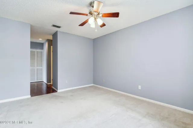 an empty room with closet and fan