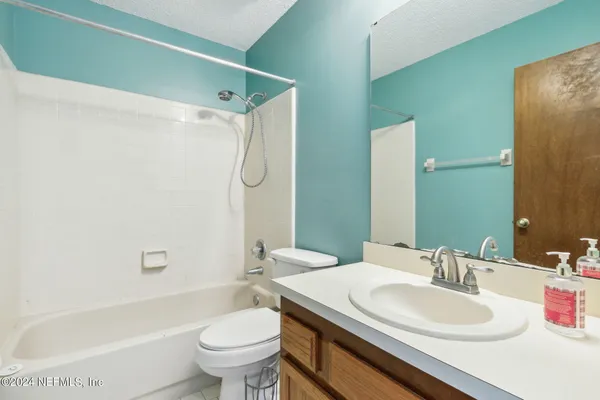 a bathroom with a granite countertop sink a toilet and a mirror
