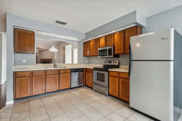 a kitchen with stainless steel appliances granite countertop a refrigerator sink and cabinets
