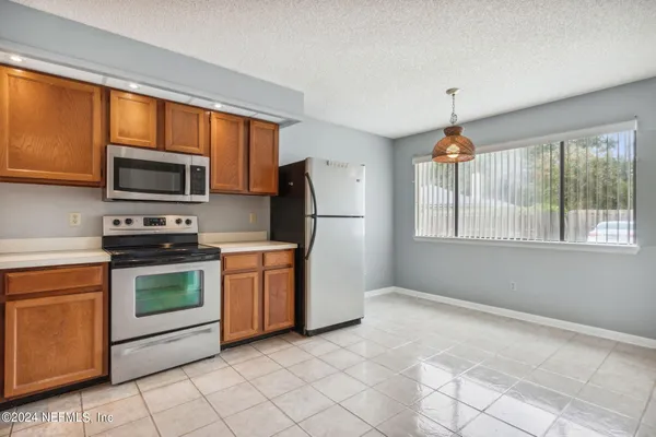a kitchen with granite countertop a stove top oven a sink dishwasher a refrigerator and a microwave