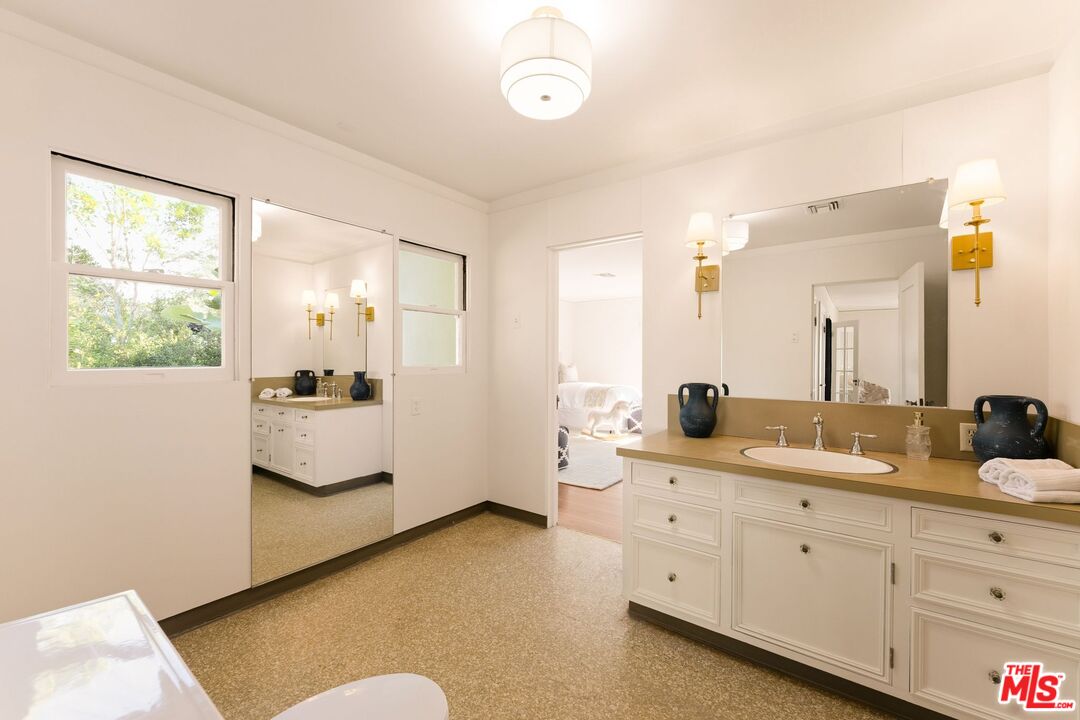 441 South Muirfield Road Los Angeles, CA 90020 - Photo 27 of 33 a en suite bathroom with double vanity and a mirror