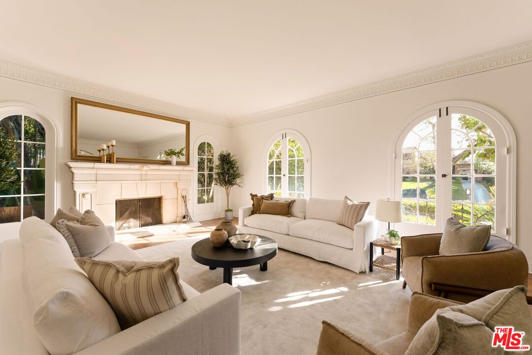 441 South Muirfield Road Los Angeles, CA 90020 - Photo 8 of 33 a living room with furniture a fireplace and a large window with garden view