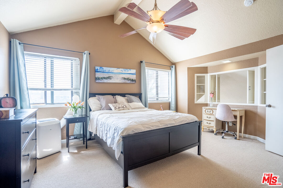 7489 Brookside Road Rancho Cucamonga, CA 91730 - Photo 15 of 41 a bedroom with a large bed a chandelier and windows