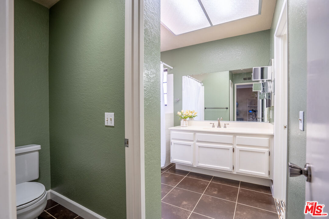 7489 Brookside Road Rancho Cucamonga, CA 91730 - Photo 24 of 41 a bathroom with a mirror a sink and toilet