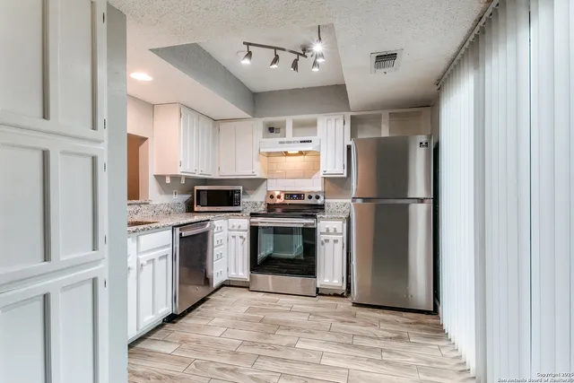 a kitchen with a refrigerator stove and microwave