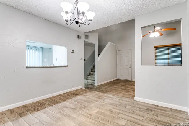 a view of a livingroom with wooden floor and a chandelier