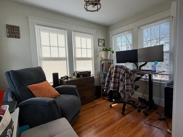 a livingroom with workspace and a window
