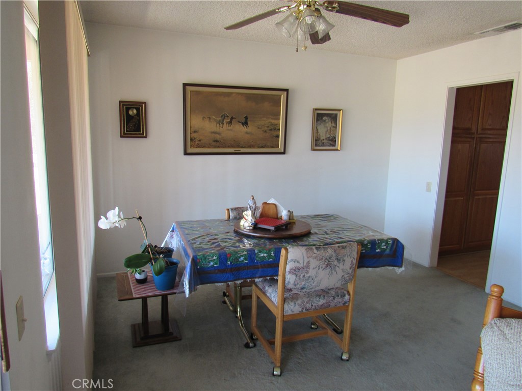 26541 Chambers Avenue Menifee, CA 92586 - Photo 16 of 61 a view of a dining room with furniture and a chandelier fan