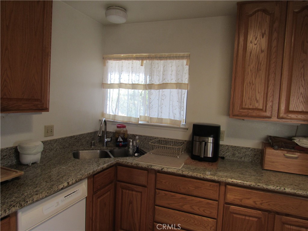 26541 Chambers Avenue Menifee, CA 92586 - Photo 34 of 61 a kitchen with granite countertop a sink a stove and cabinets