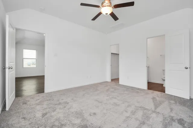 an empty room with fan and windows