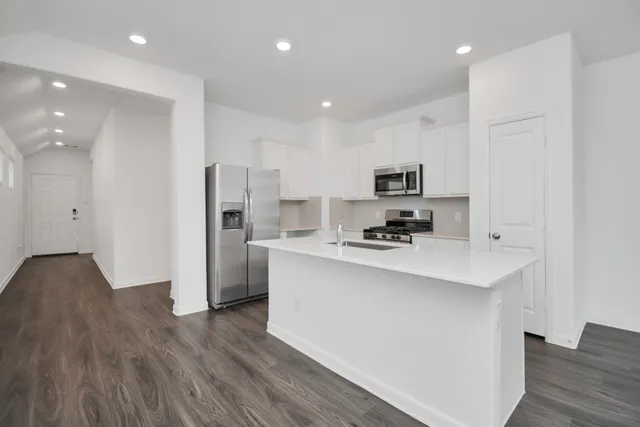 a kitchen with stainless steel appliances a refrigerator stove a sink and a oven