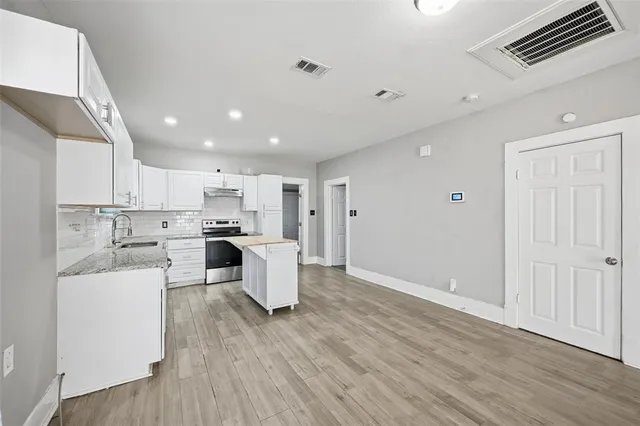a view of a kitchen and dining room with furniture wooden floor kitchen view and a window