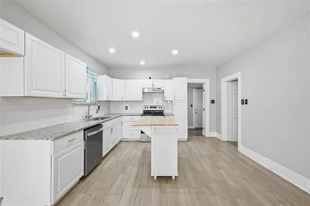 a large kitchen with cabinets wooden floor and stainless steel appliances
