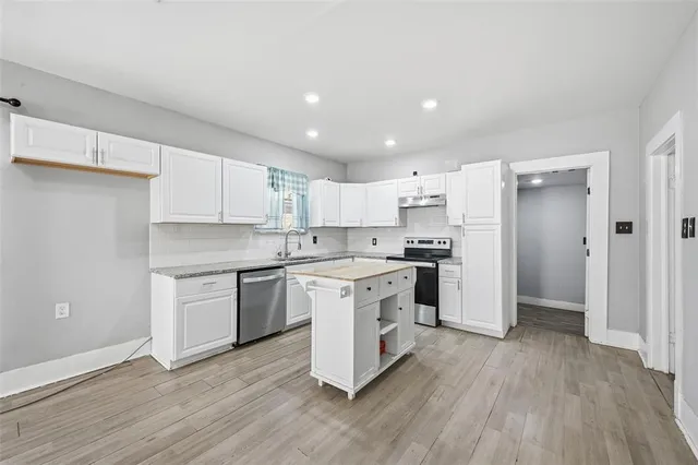 a kitchen with a white stove a sink and a refrigerator
