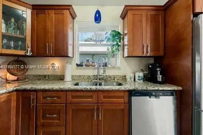 a kitchen with granite countertop stainless steel appliances a sink window and cabinets