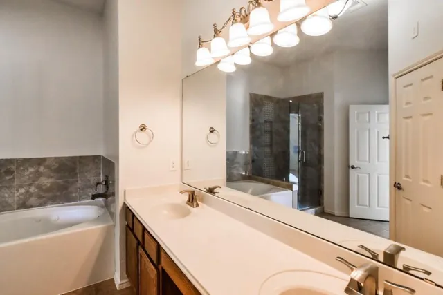 a bathroom with a tub a sink and shower