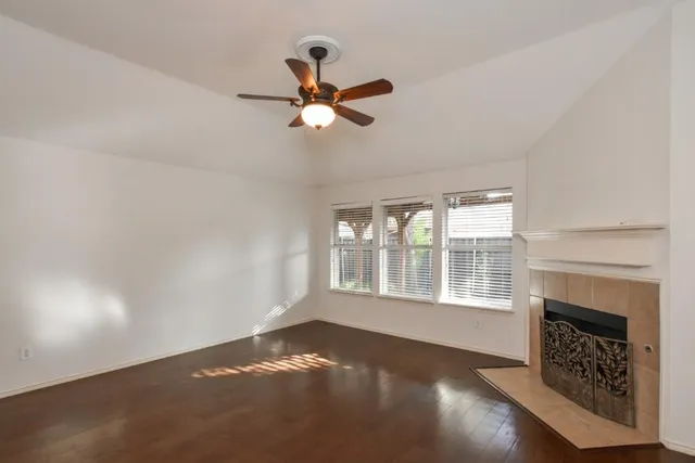 a view of wooden floor fire place and windows in a room
