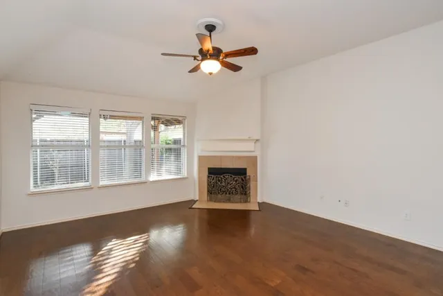 a view of a livingroom with wooden floor and a large window