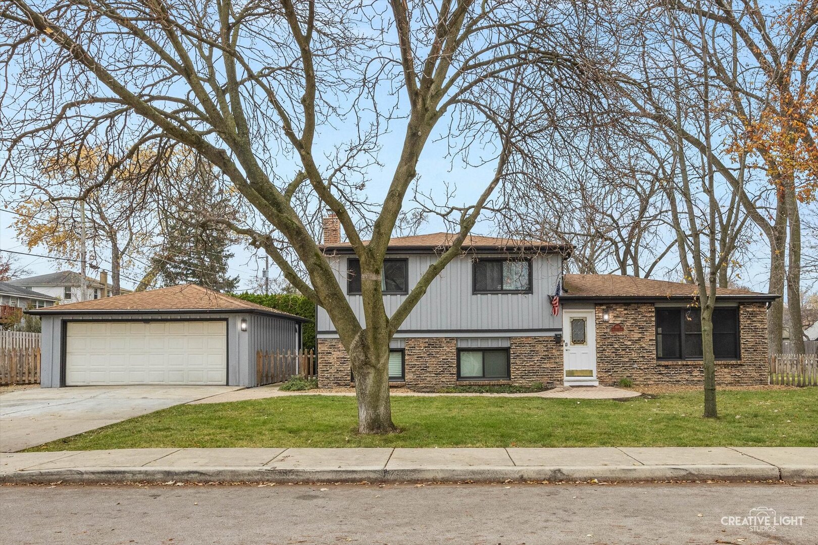 a front view of a house with a garden and trees