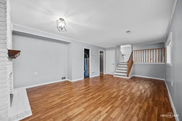 a view of an empty room with a fireplace and a window