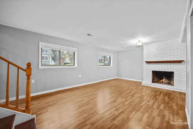 a view of empty room with wooden floor and fireplace