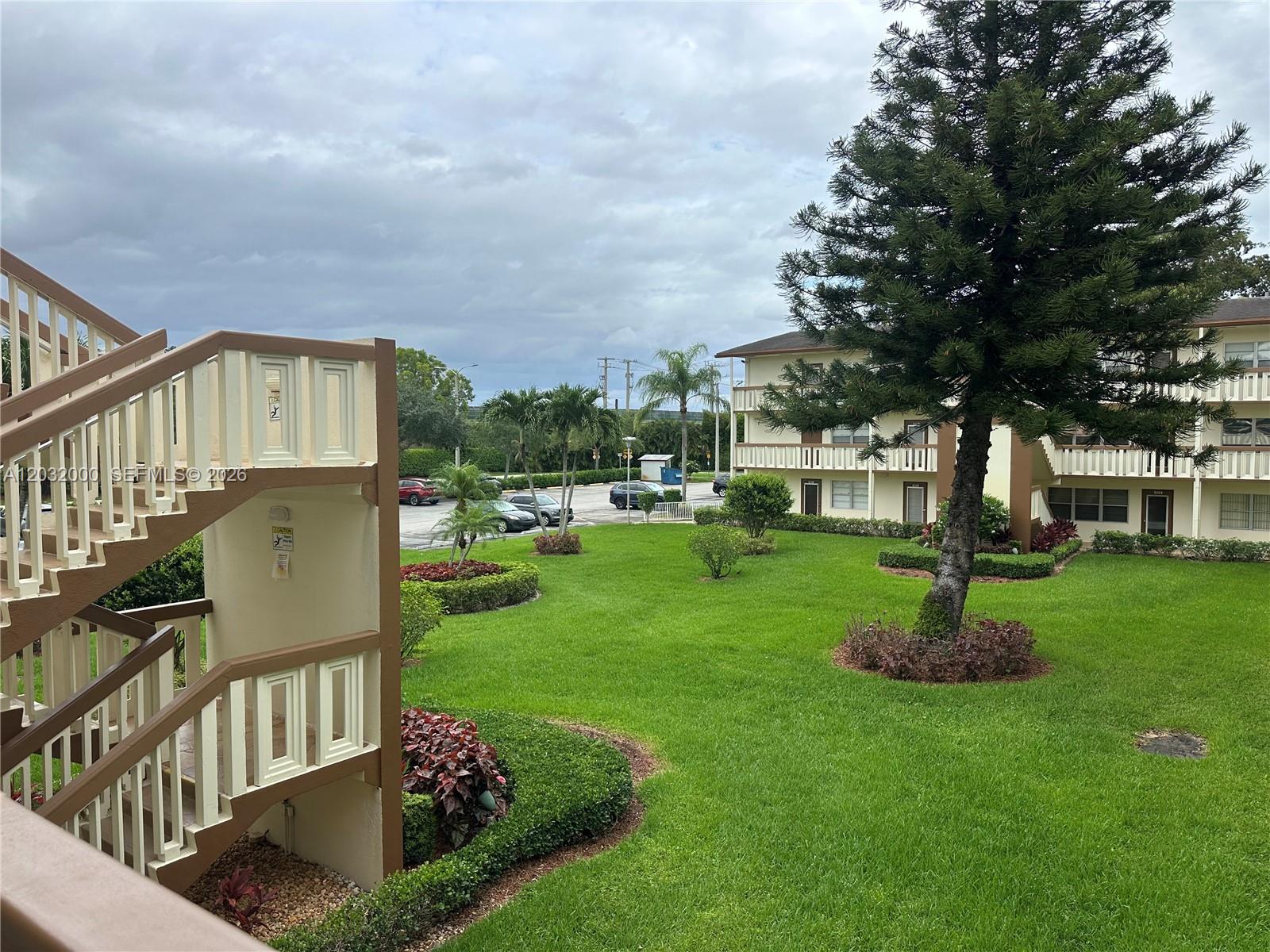 445 Mansfield K, Unit 445 Boca Raton, FL 33434 - Photo 2 of 12 a view of a house with a yard and a garden