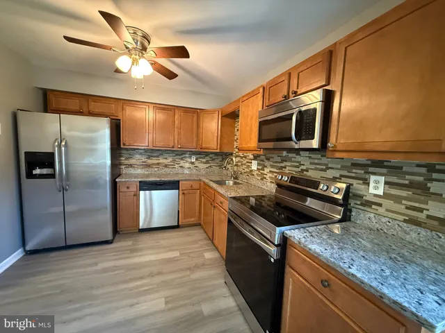 a kitchen with stainless steel appliances granite countertop a stove a sink and a microwave