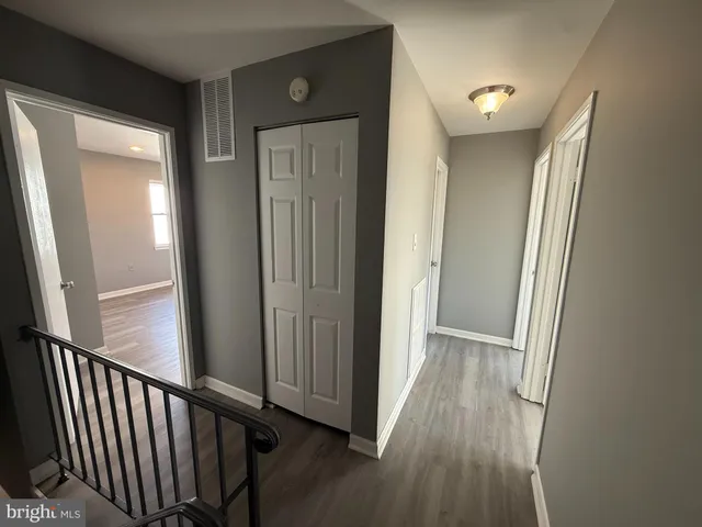 a view of a hallway with wooden floor and a window