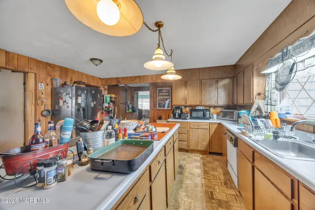 a kitchen with stainless steel appliances granite countertop a sink a stove and a wooden floors