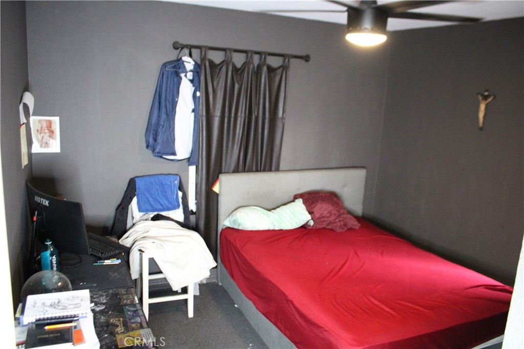 2412 West Alondra Boulevard Compton, CA 90220 - Photo 16 of 32 a bedroom with a bed a chair and potted plants on the dresser