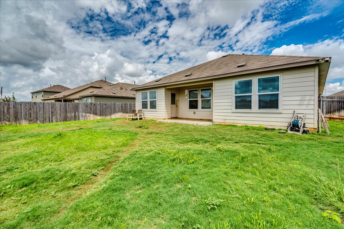 389 Salt Springs Road Kyle, TX 78640 - Photo 27 of 30 A spacious backyard with a generous lawn awaits, perfect for outdoor activities and relaxation.