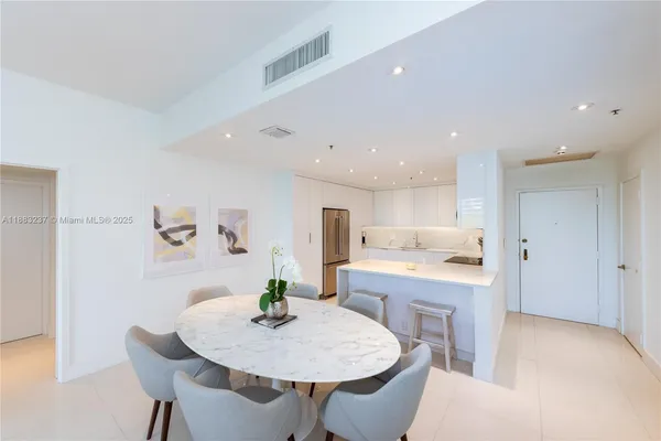 a living room with stainless steel appliances furniture a dining table and chairs