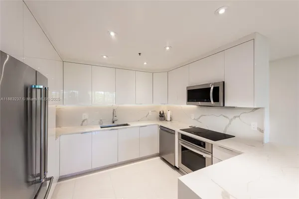 a kitchen with stainless steel appliances a sink a stove a microwave and cabinets