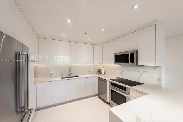 a kitchen with stainless steel appliances a sink a stove a microwave and cabinets