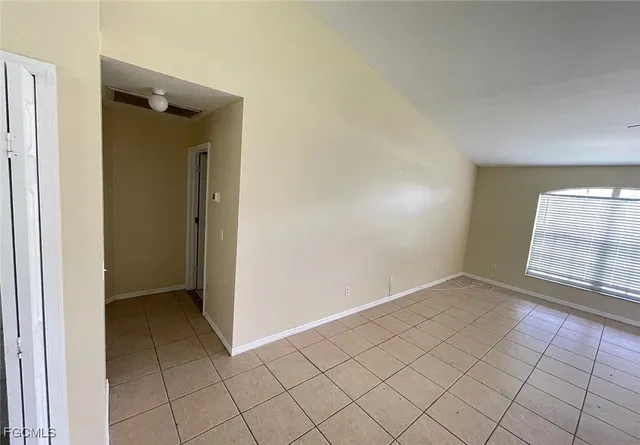 an empty room with closet and a chandelier fan