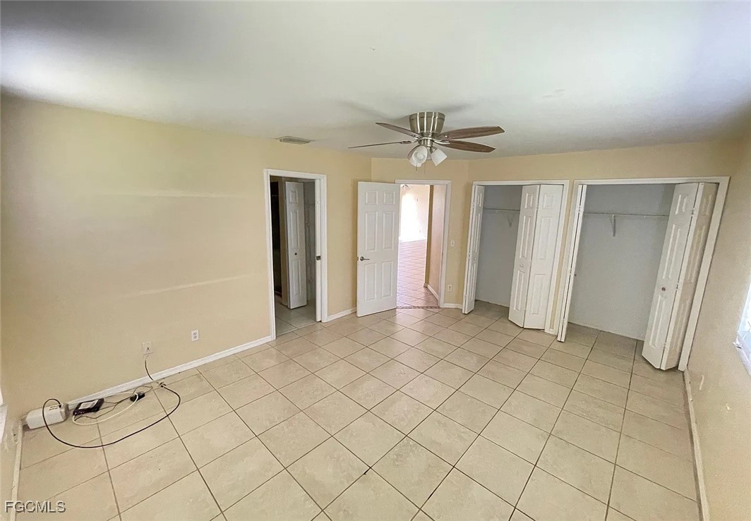 819 Abrams Boulevard Lehigh Acres, FL 33971 - Photo 5 of 10 an empty room with closet and a chandelier fan