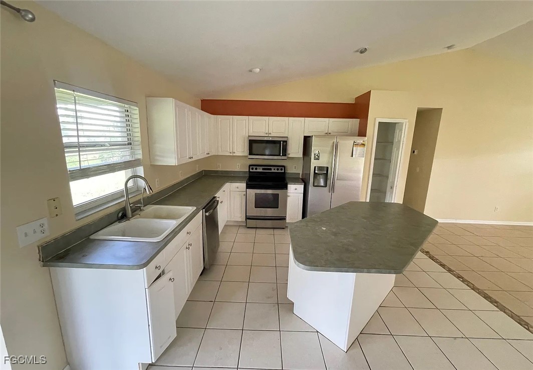 819 Abrams Boulevard Lehigh Acres, FL 33971 - Photo 6 of 10 a kitchen with stainless steel appliances granite countertop a sink a stove and a refrigerator