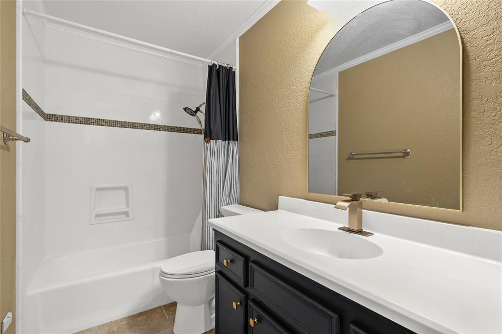 310 Ruth Drive Hewitt, TX 76643 - Photo 10 of 25 Bathroom featuring a dark vanity with gold-tone hardware, a white integrated sink, and a gold-tone faucet full size tub
