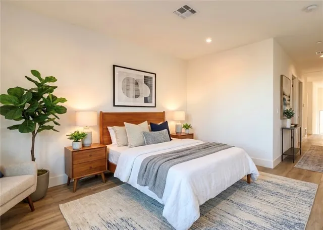 a bedroom with a bed a couch and potted plant